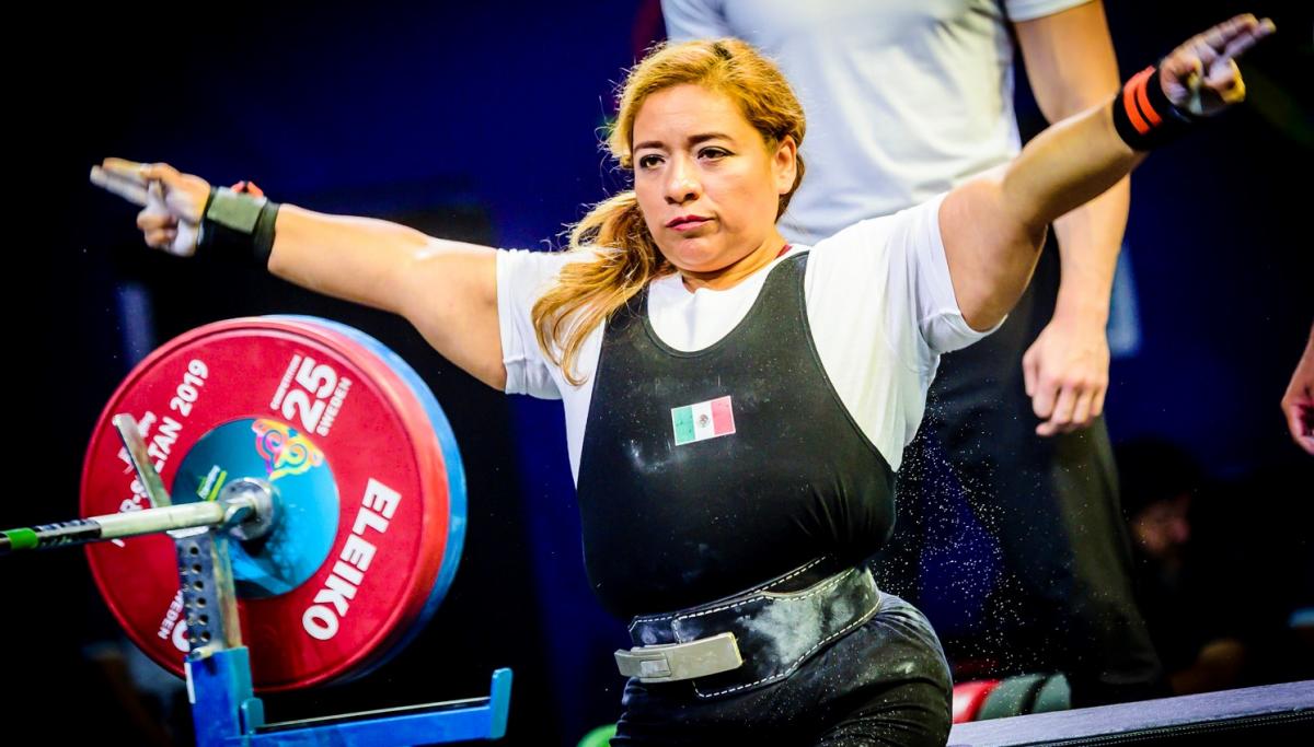 A woman stretching her arms before competing in a powerlifting bench press