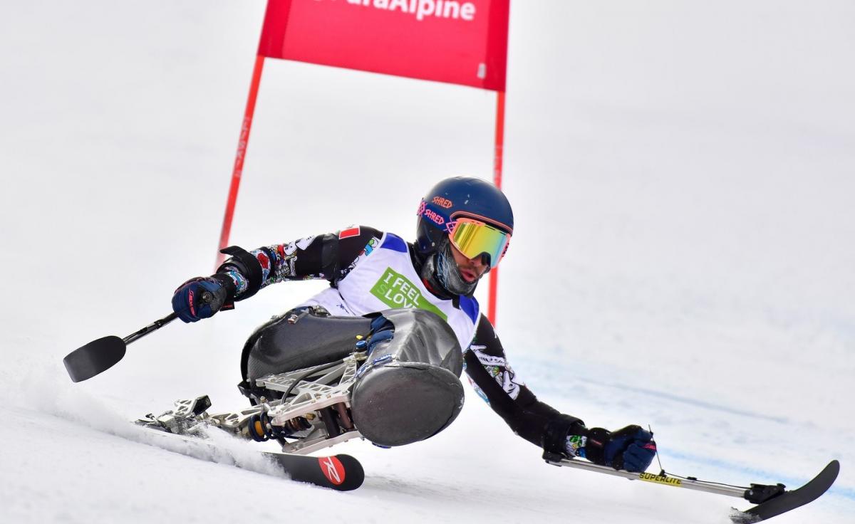 A male sit-skier competing on a giant slalom event