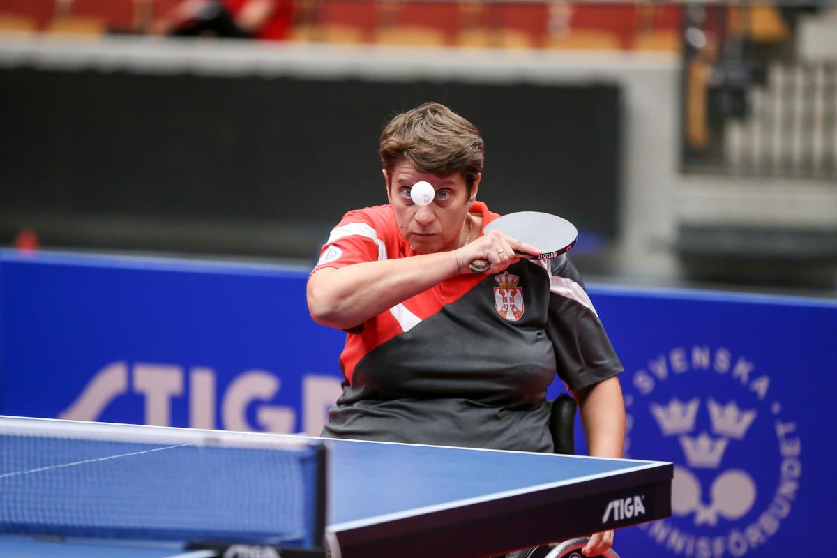 Female table tennis player in wheelchair returns a shot