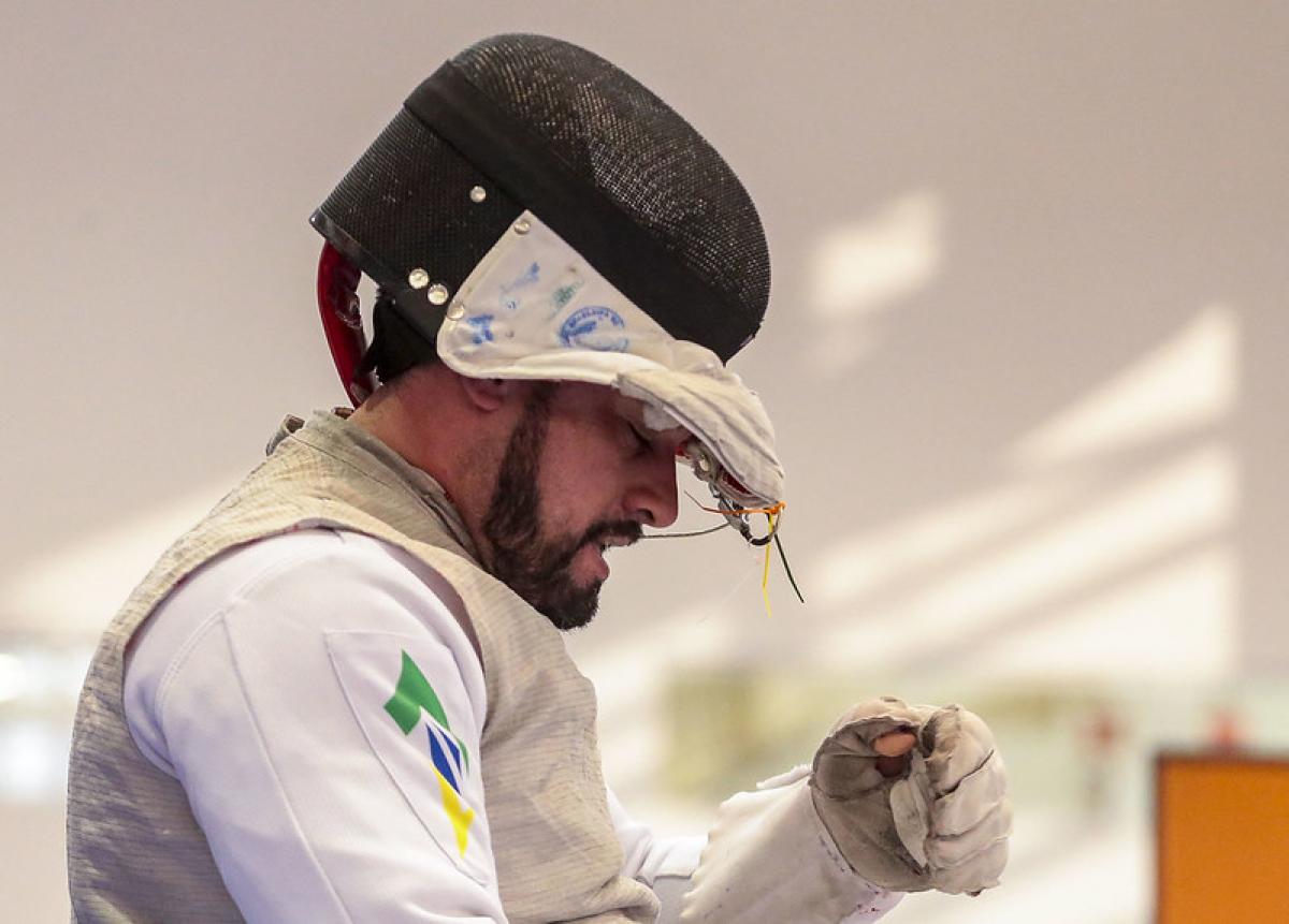 Brazilian male wheelchair fencer pulls off his mask