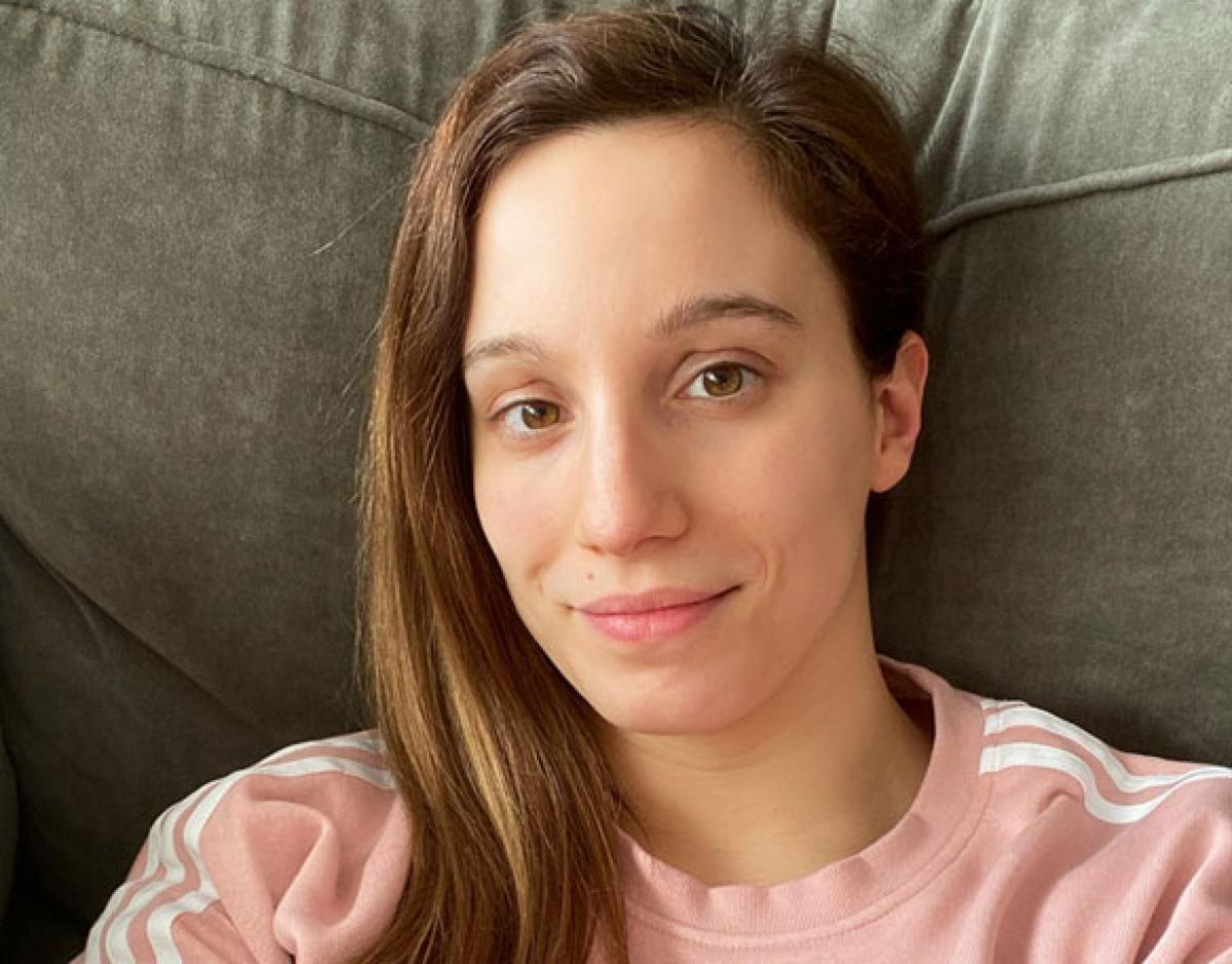 A woman wearing a pink shirt looking at the camera