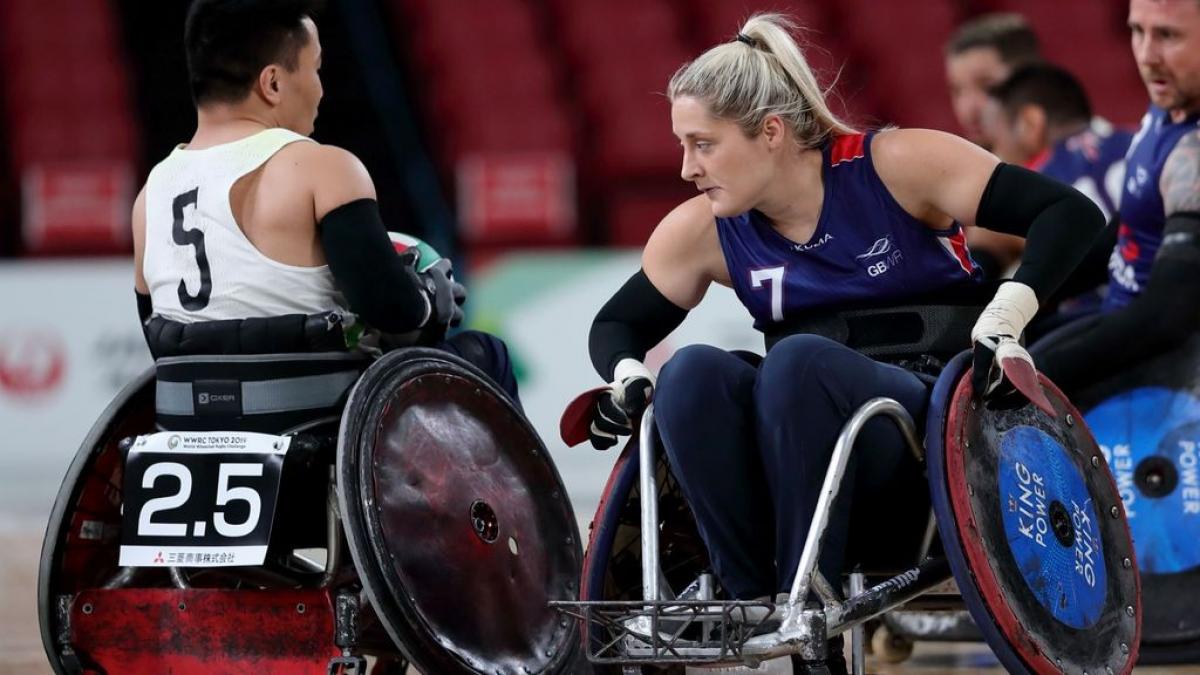 Female wheelchair rugby player stops an opponent