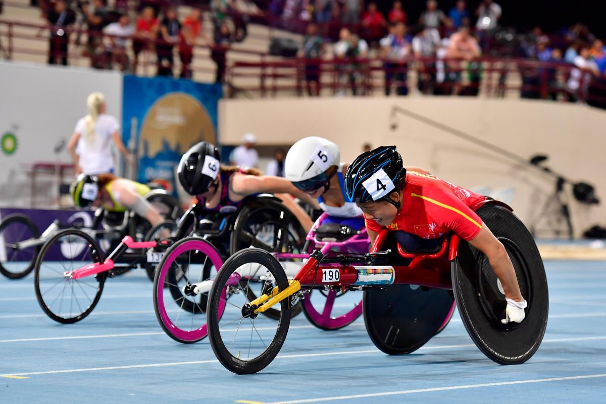 Four female wheelchair racers racing on the track