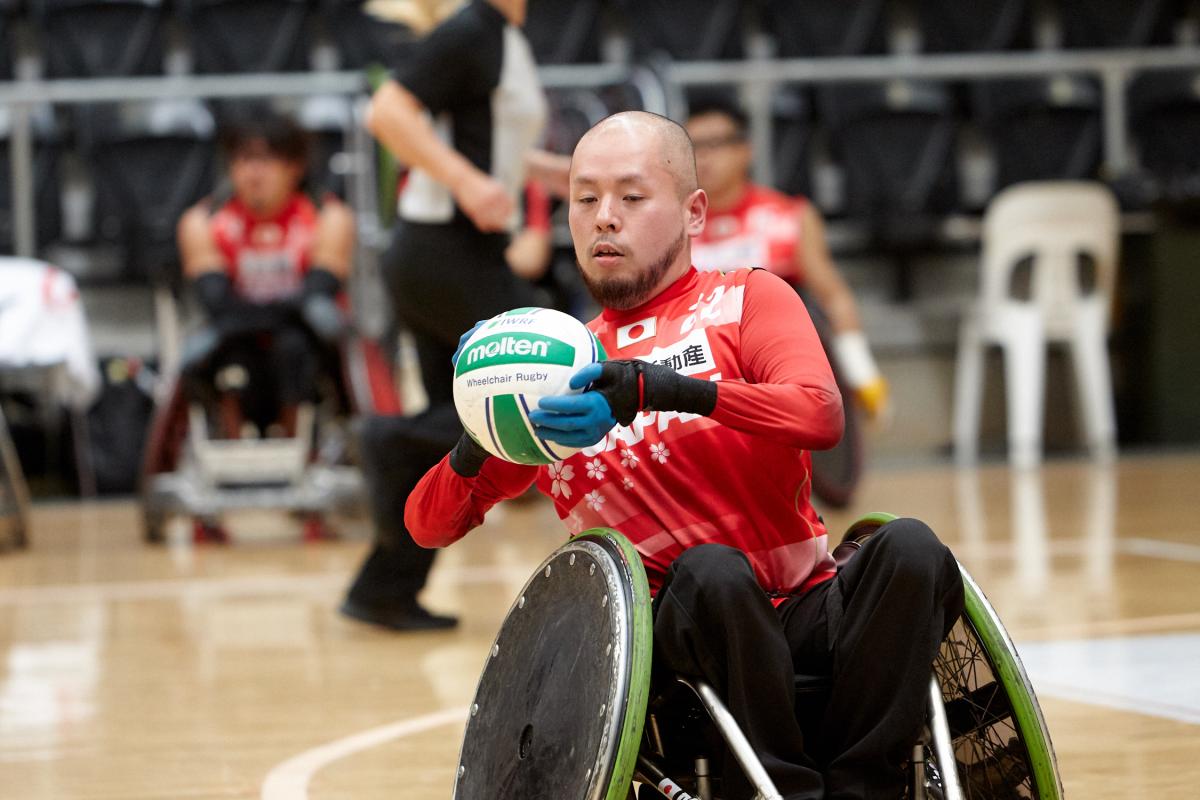 Male Japanese wheelchair rugby player holding a ball