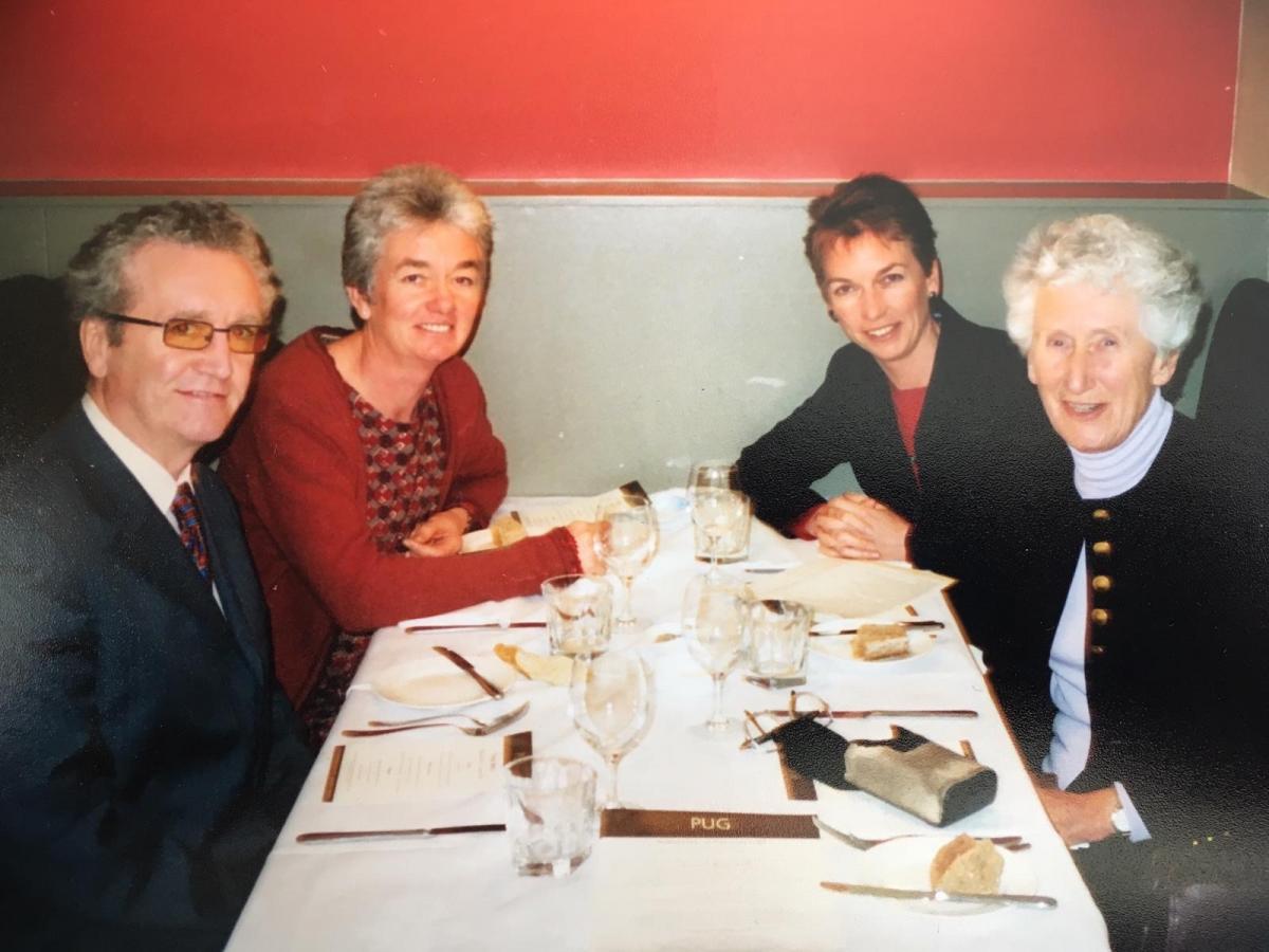 Photo of four people at a restaurant table smiling for a photo