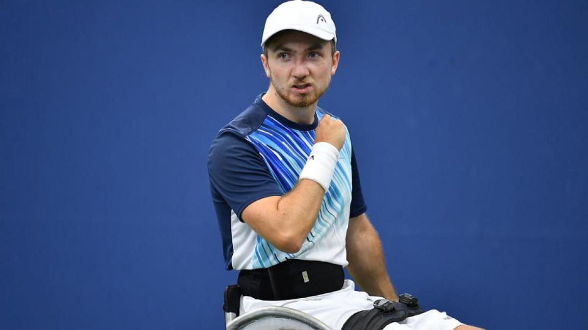 Dutch male wheelchair tennis player makes a fist after scoring a point