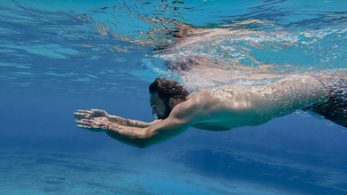 A man swimming underwater in the sea 