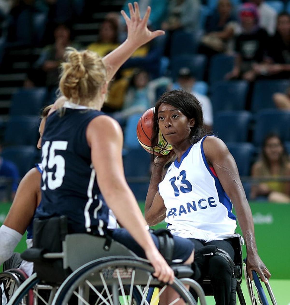 Female wheelchair basketball player defended strongly by her opponent