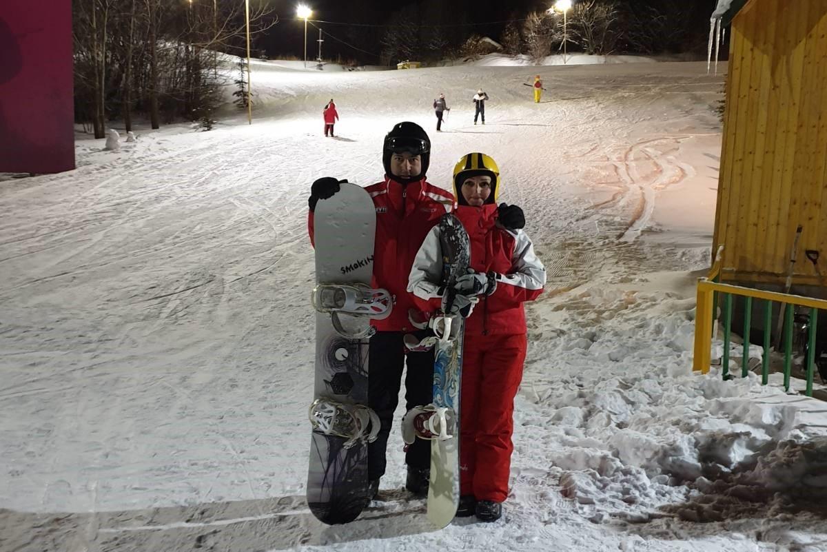 A man and a woman with snowboard gear standing in a snowy slope