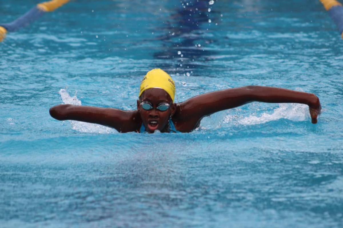 Black female swimmer with missing forearm swimming