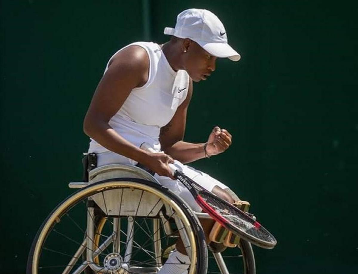 Black female wheelchair tennis player celebrates a point