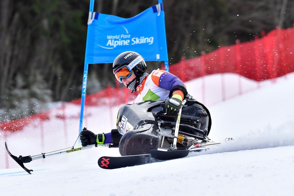 A female sit-skier competing in a giant slalom Para alpine skiing event