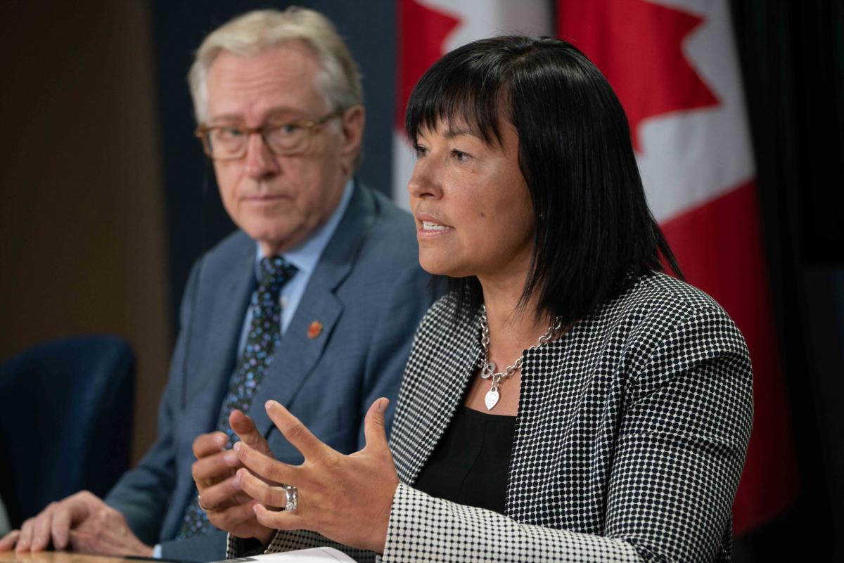 Chantal Petitclerc speaks with Canadian flag behind