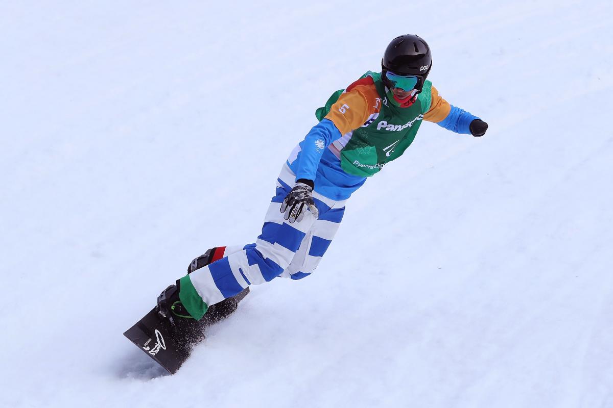 An one-armed man competing in a snowboard event 