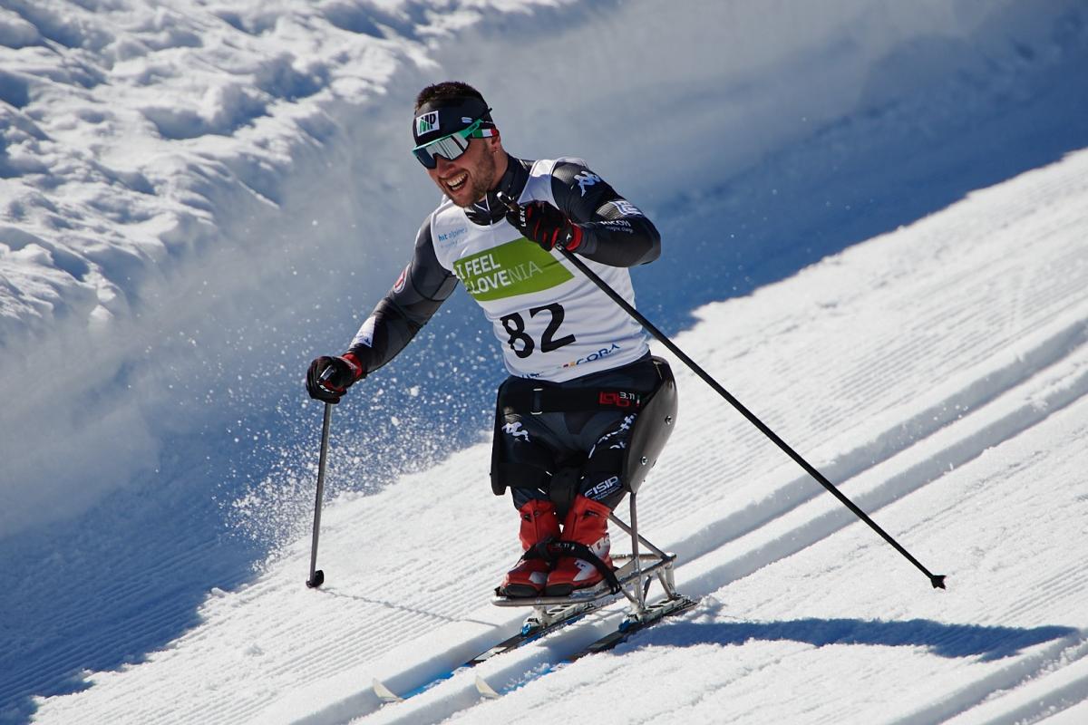 A man in a sit skiing competing in a cross-country event in the snow