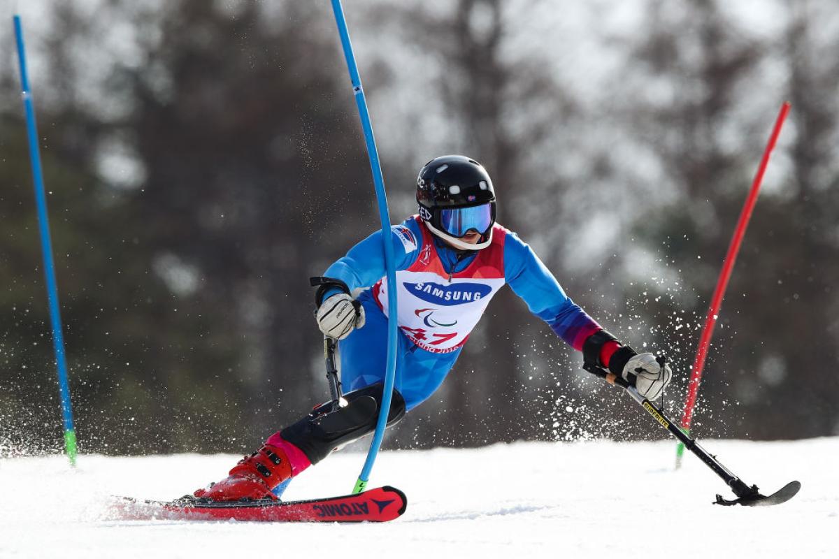 Male alpine skier with left leg impairment competes in slalom 