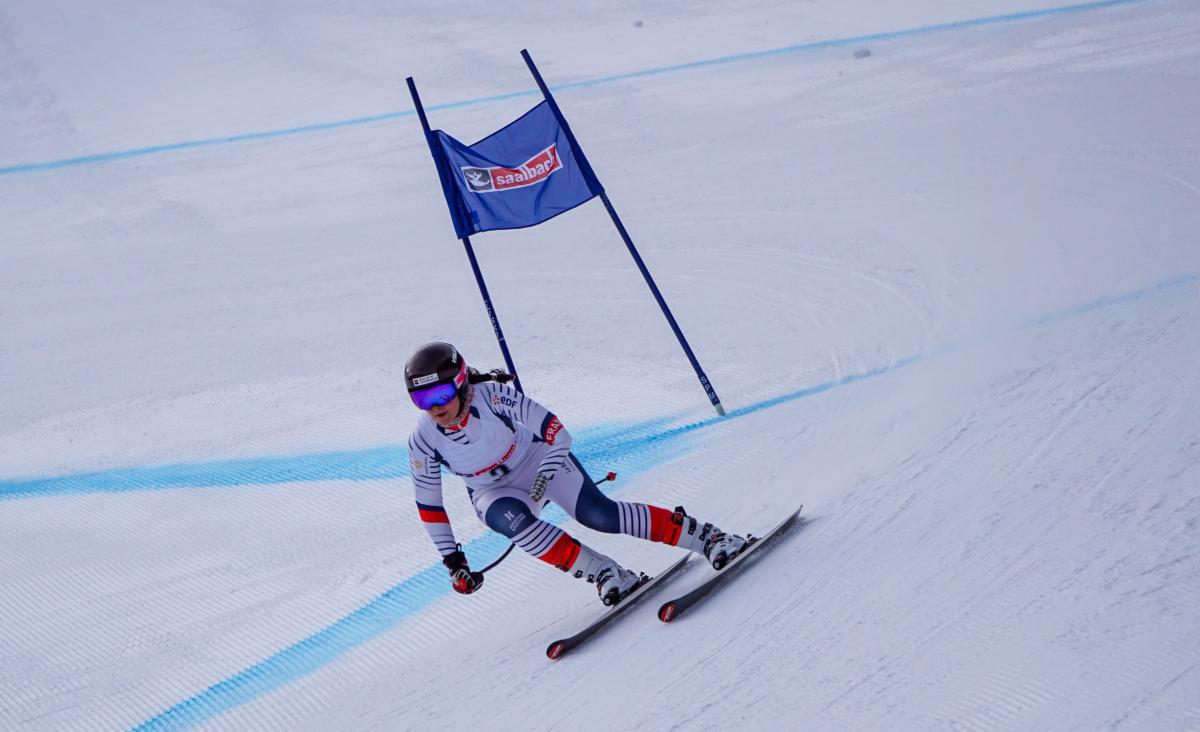 A female Para alpine skier competing in a downhill race