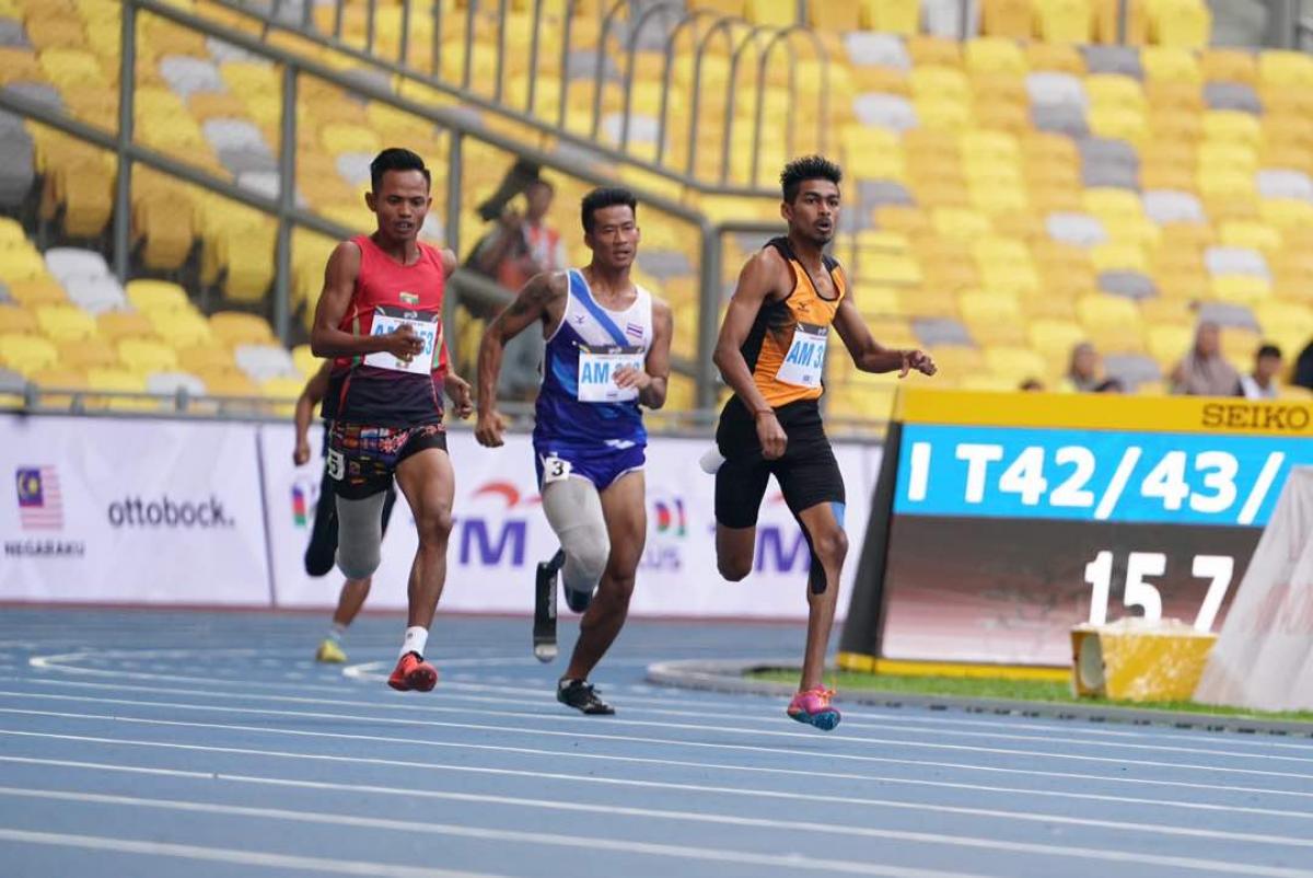 Three Asian men sprinting to the finish line