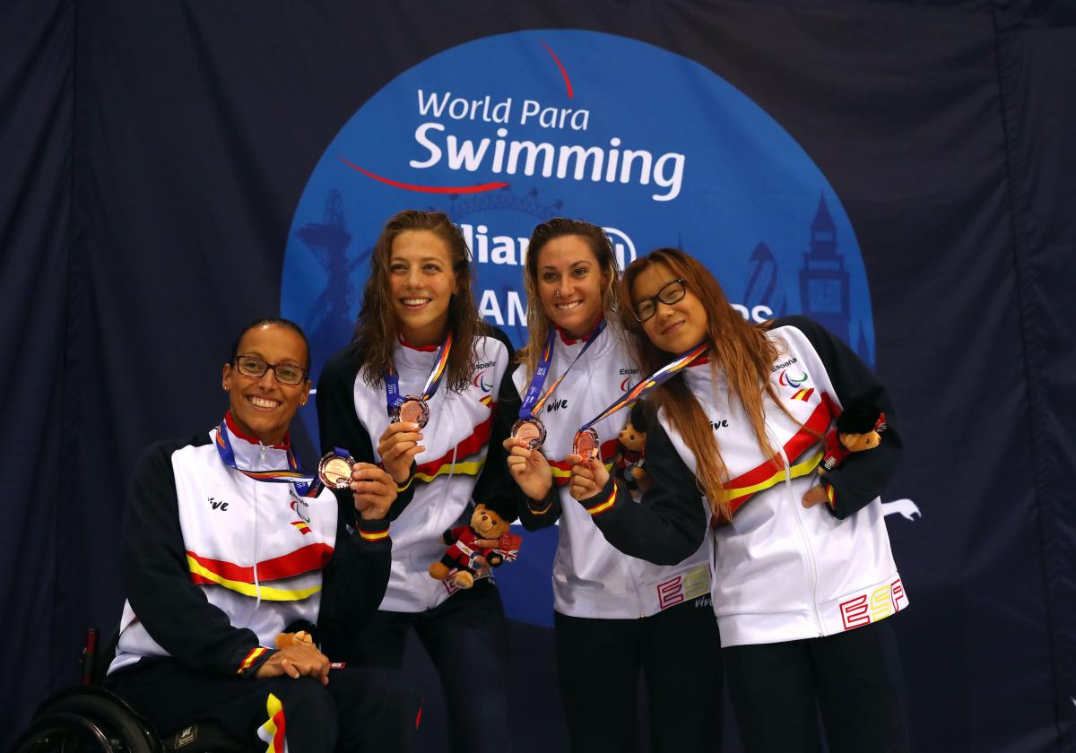 A group of four women with Spain's uniform showing their medals