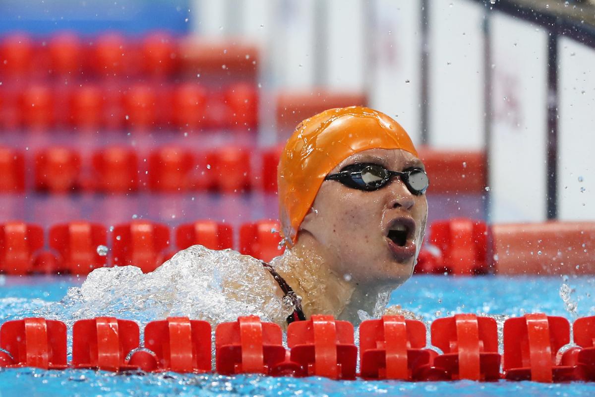 A female swimmer with orange cap in the water