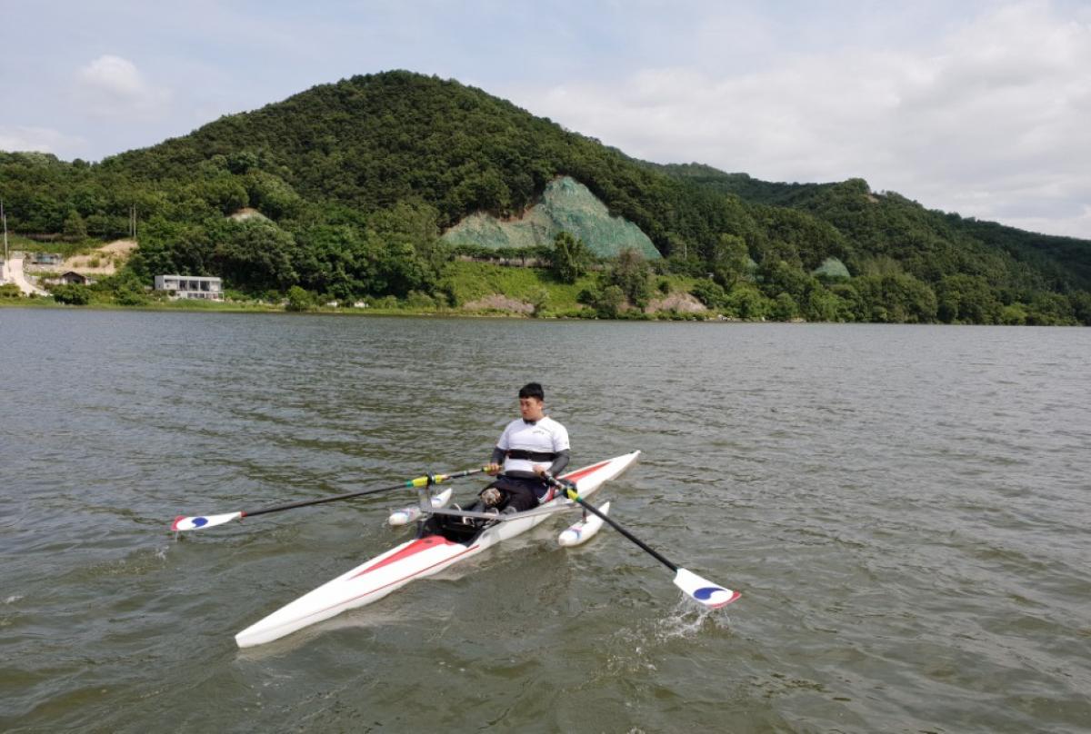 Man on rowing boat with scenic background