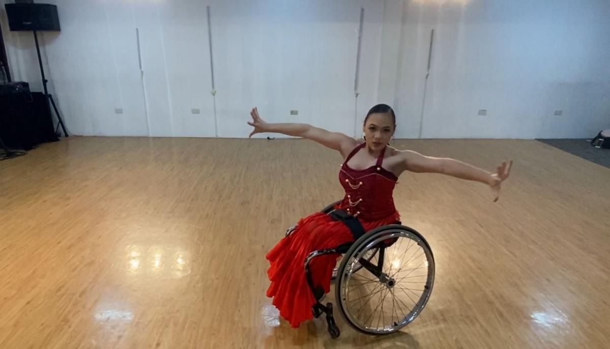 A woman in a wheelchair dancing in a room