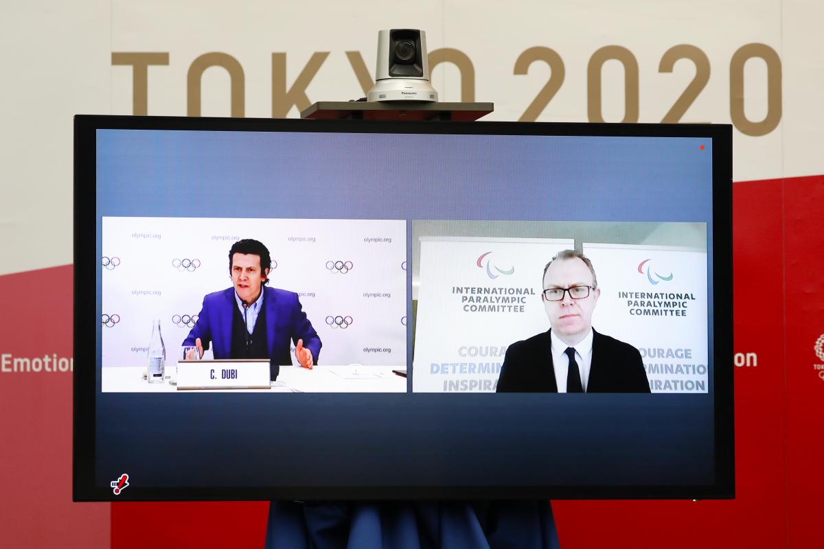 A monitor shows the IOC's Olympic Games Operations Director Pierre Ducrey and IPC's Chief Brand and Communications Officer Craig Spence participating remotely in the Tokyo 2020 Playbooks Press Briefing