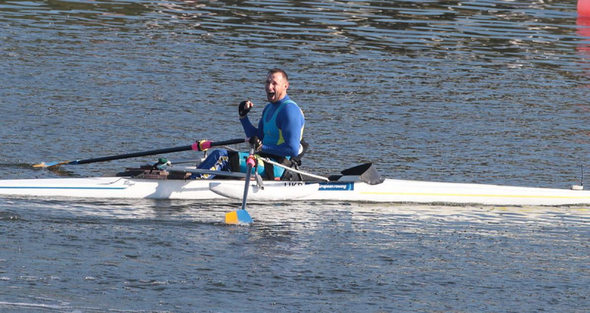 Man celebrates in rowing boat