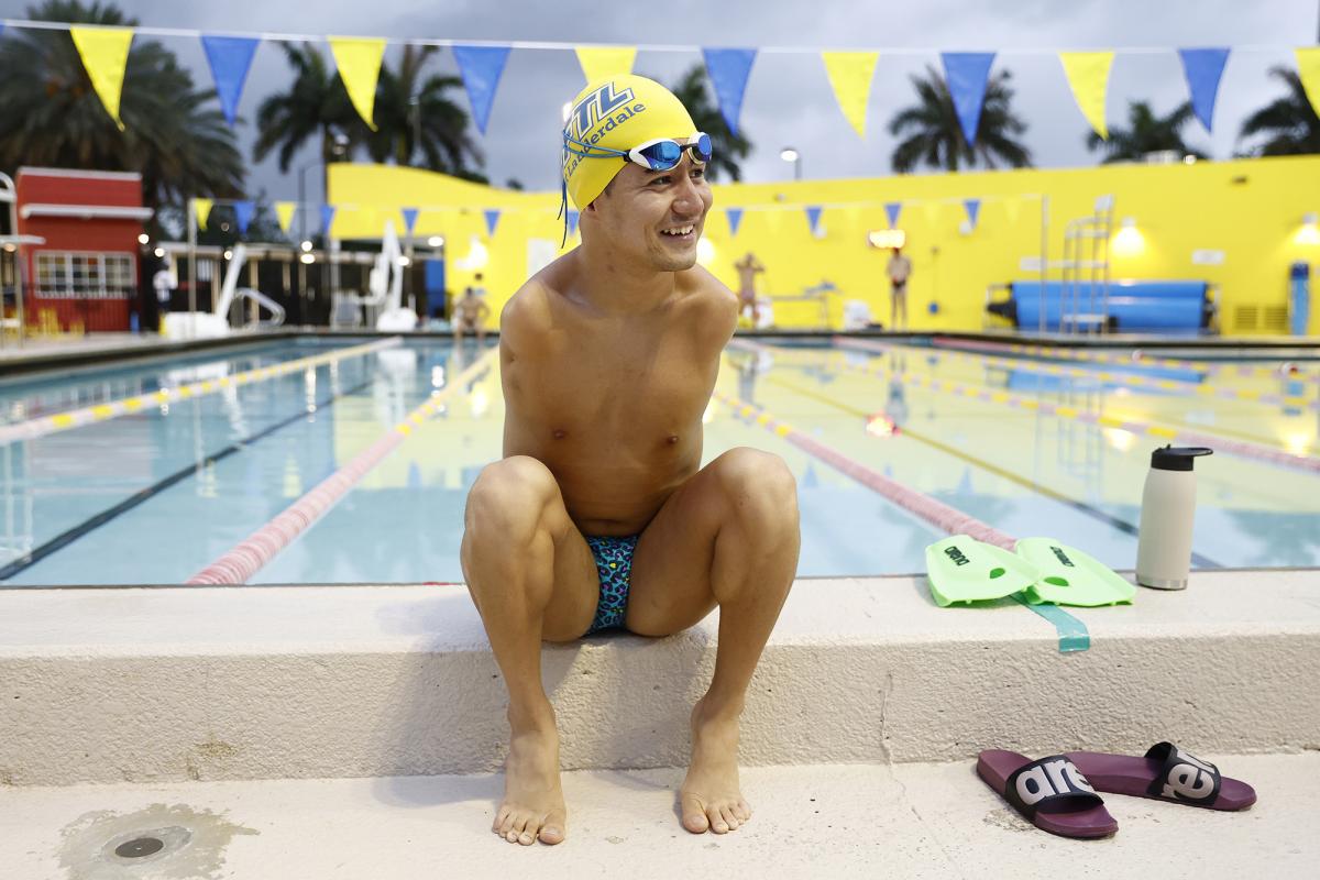 Mohammad Abbas Karimi smiling while sitting next to a swimming pool