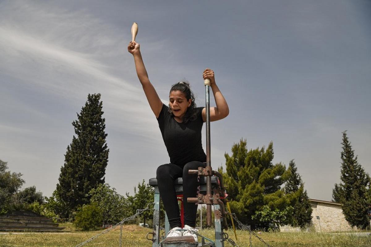 Para athlete on a chair throwing a club