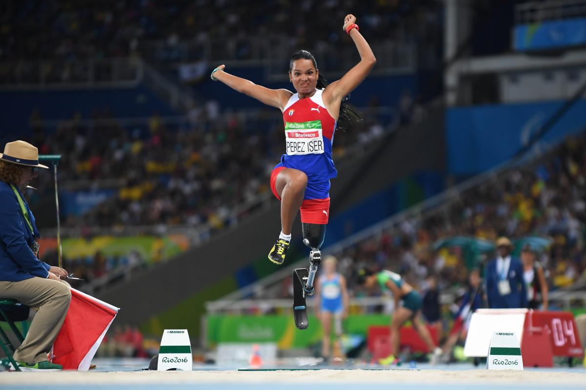 Cuban athlete with a prosthesis in the air after jumping while competing in the long jump
