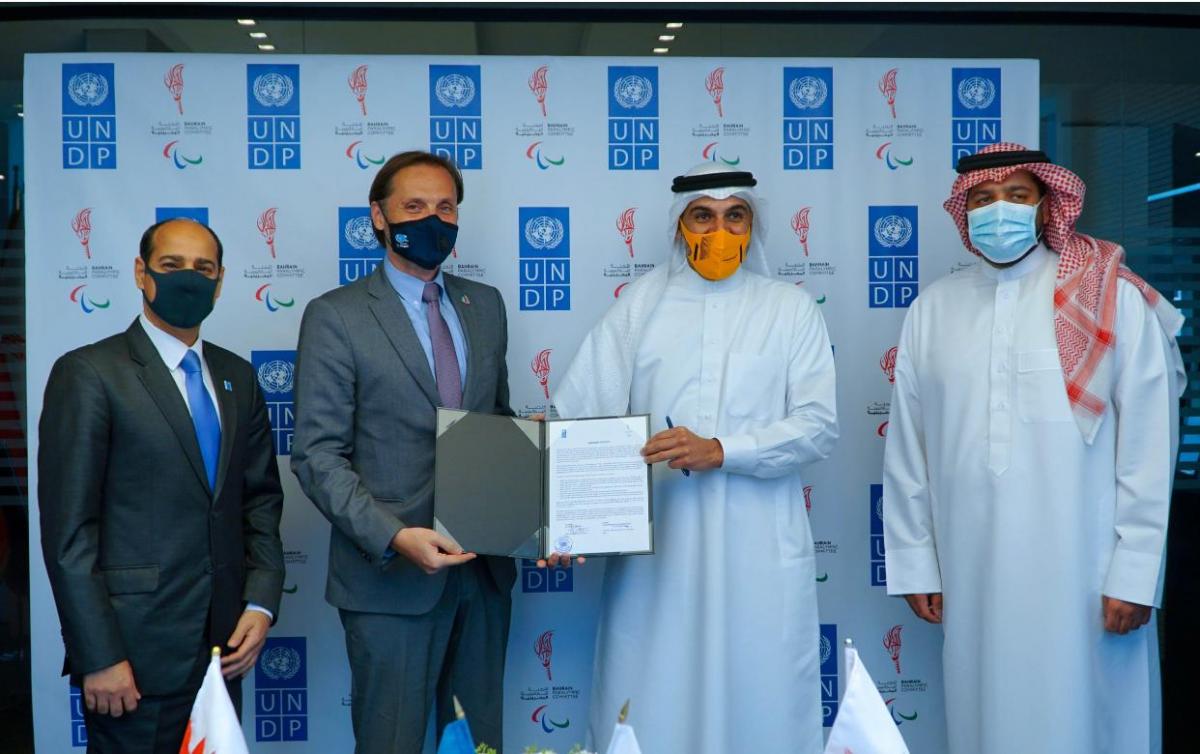 Group of men posing for photo holding signed agreement