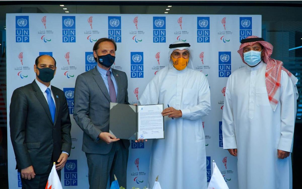 Group of men posing for photo holding  signed agreement