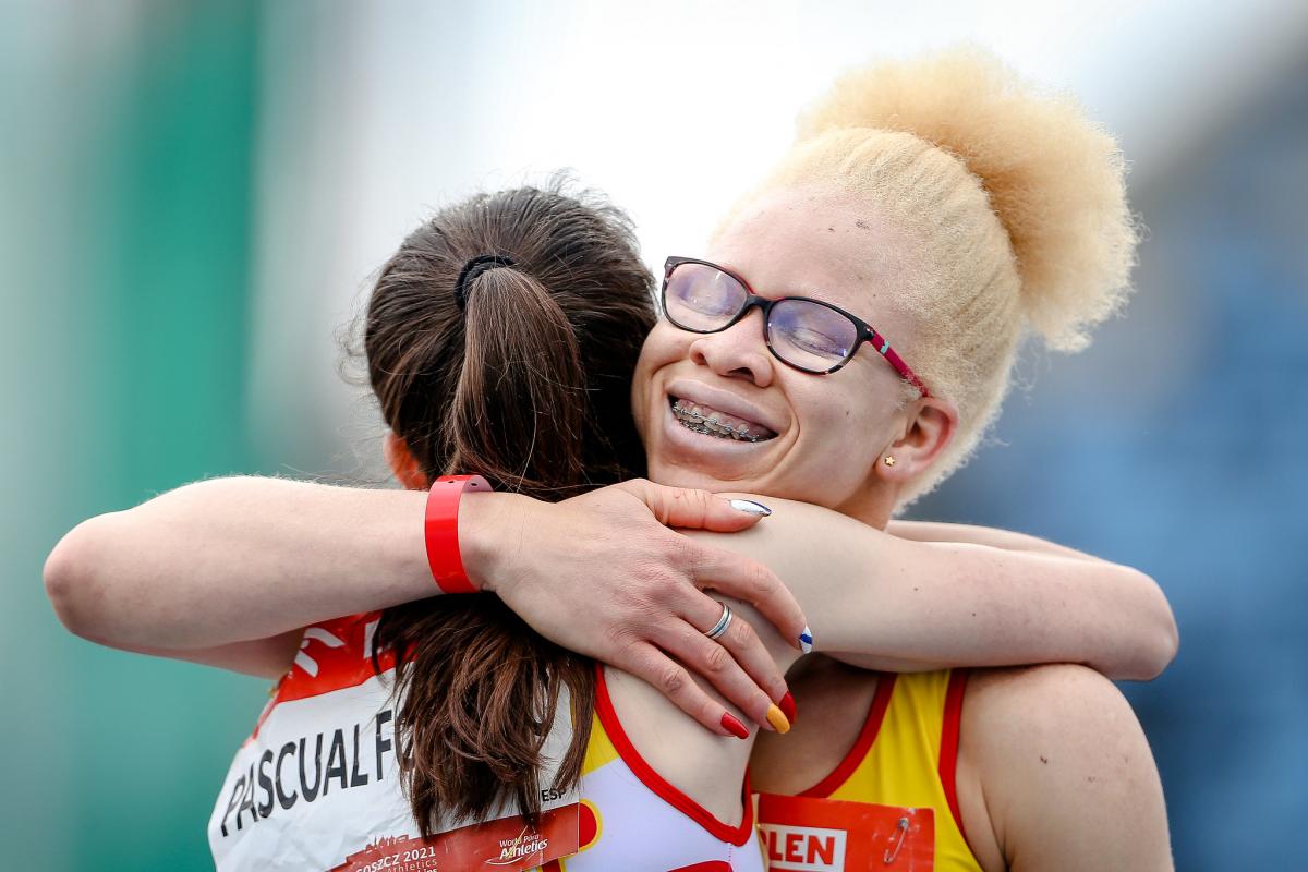 A woman with glasses hugging another woman