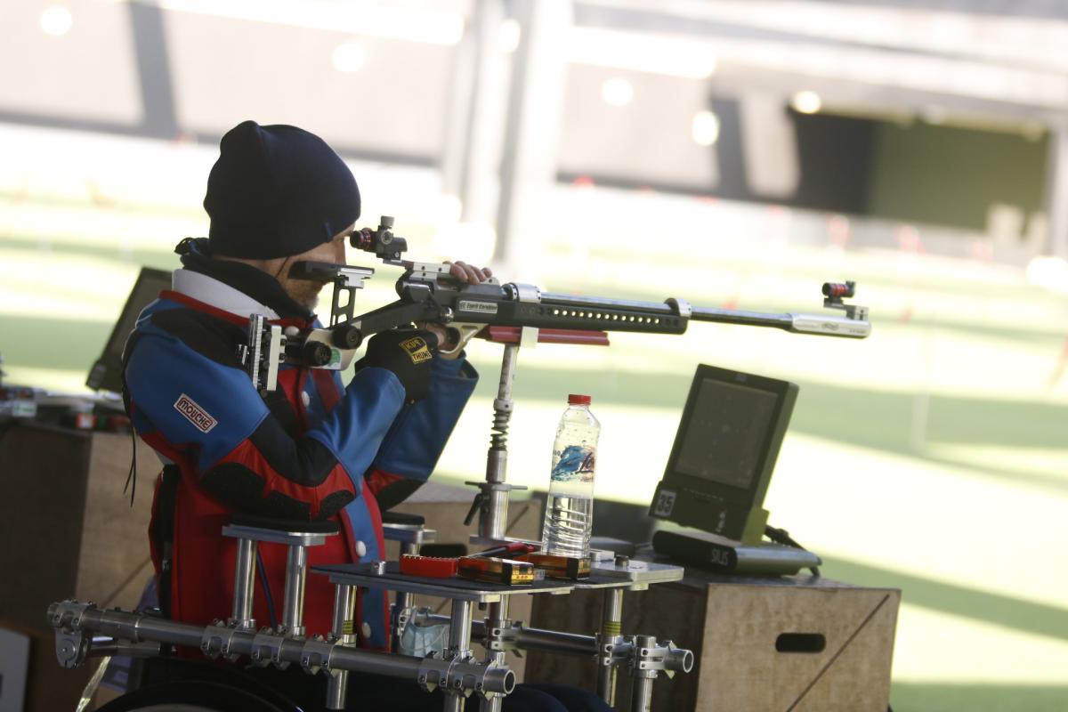 A man with a rifle competing in a shooting range