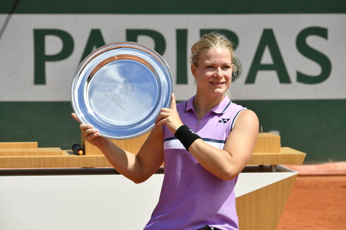 Diede de Groot holds Roland Garros' trophy and smiles to the camera