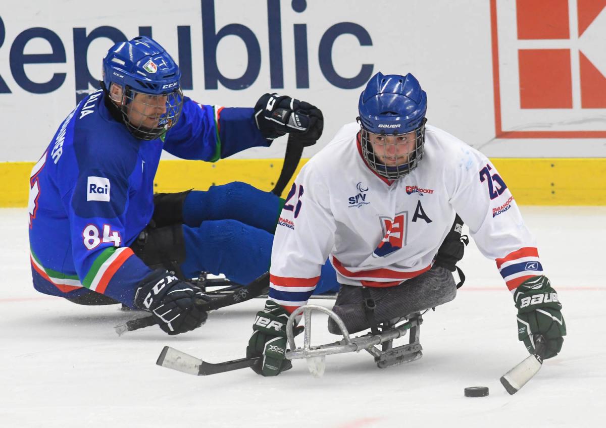 A Slovakian Para ice hockey player followed closely by an Italian player