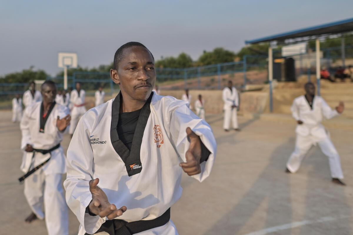 African male taekwondo athlete teaching other students