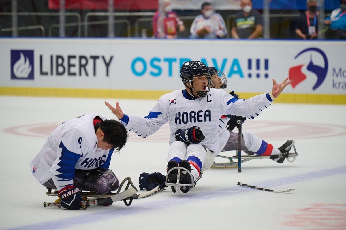 Three Para ice hockey players on ice with the uniform of South Korea