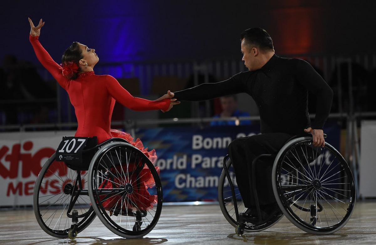 A couple in wheelchairs dancing on a Para dance sport competition