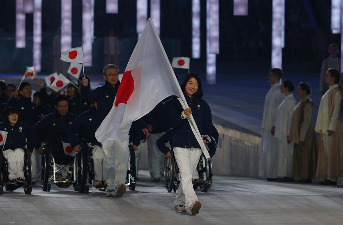 Japanese woman carries flag at Opening Ceremony