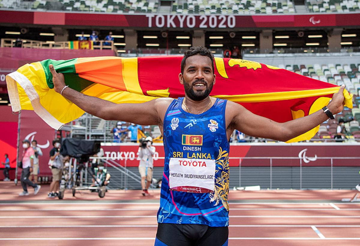 Sri Lankan male javelin thrower celebrates with country flag