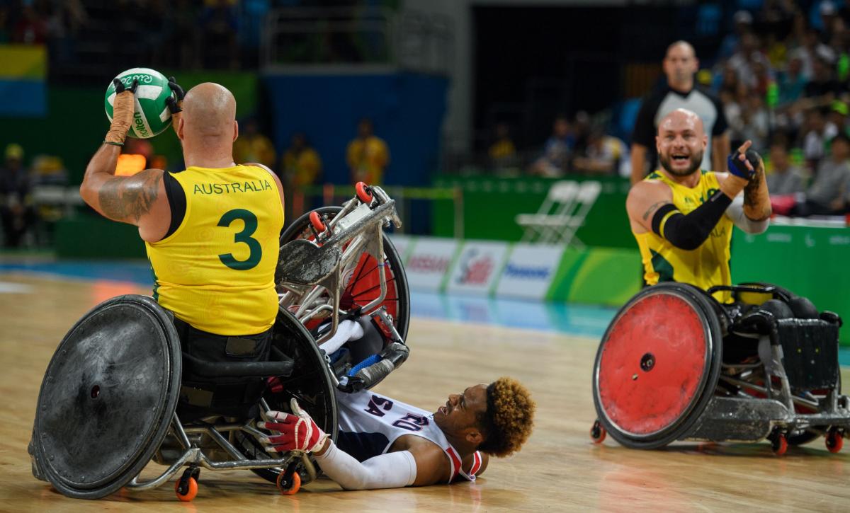 Australia captain Ryley Batt shouts to a team-mate as Josh Brewer is tipped on to the floor