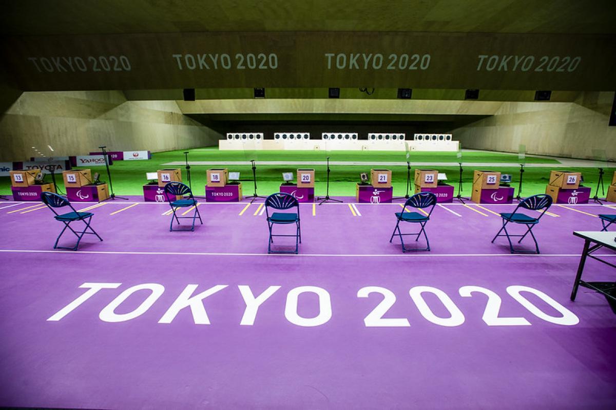 An empty indoor shooting range with Tokyo 2020 written on the floor