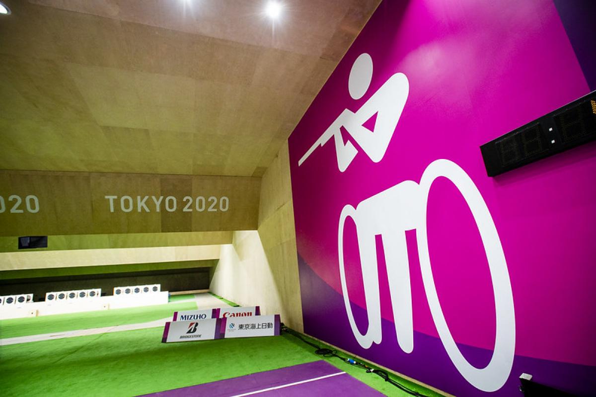 A shooting range with a wall showing the shooting Para sport pictogram at Tokyo 2020