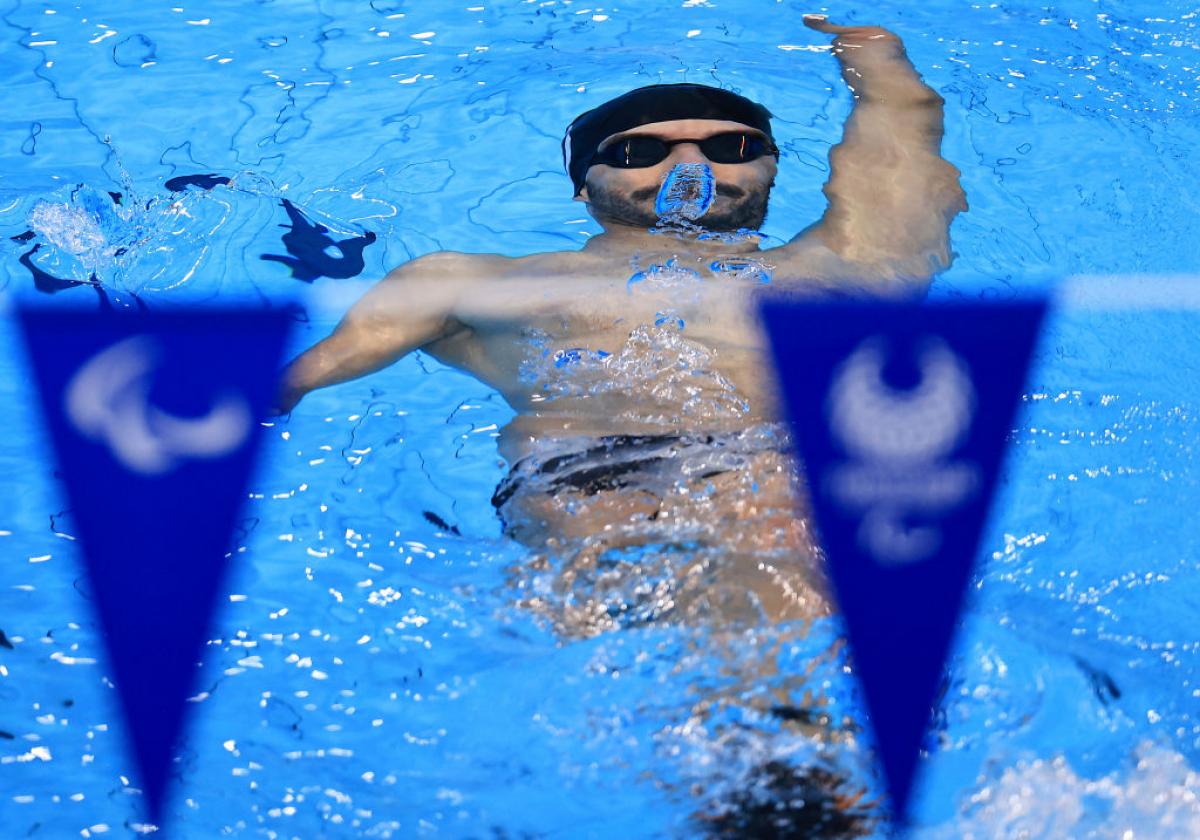A man swimming backstroke underwater in a pool