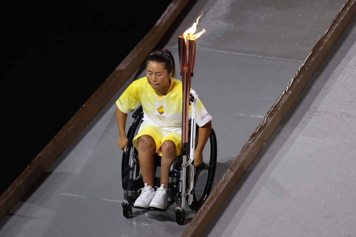 Yui Kamiji goes down ramp holding Paralympic flame at Opening Ceremony