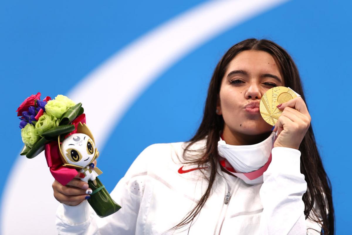 A young woman kissing her gold medal 