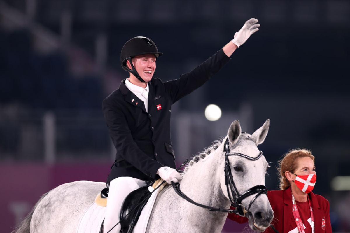  Tobias Thorning Jorgensen on his horse waves his hand in the air and smiles