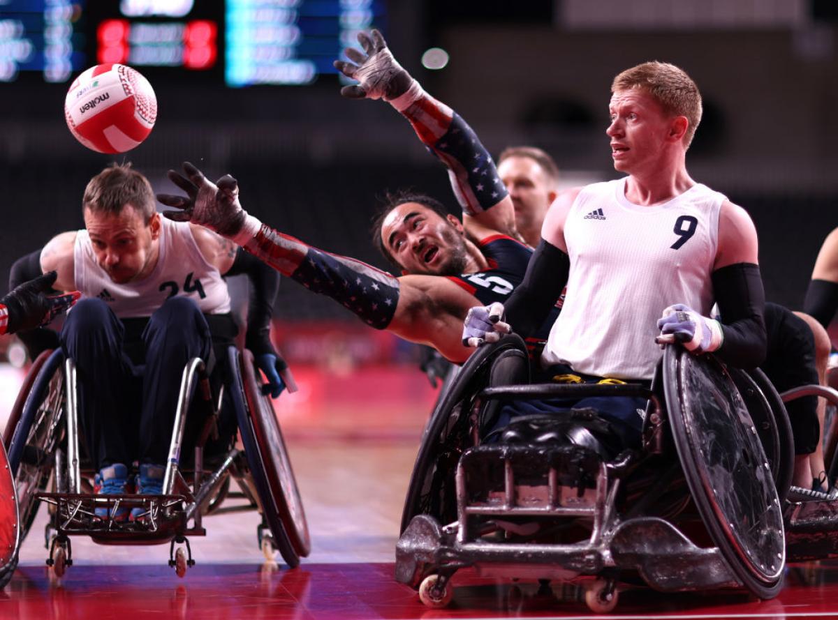 Charles Aoki reaches for the ball past Jim Roberts in the wheelchair rugby gold medal game